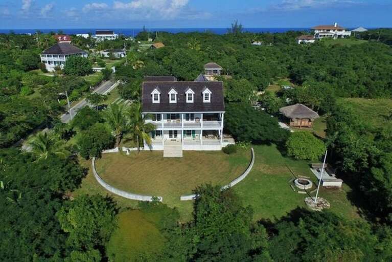 The house sits on nearly two acres with mature fruit and poinciana trees.