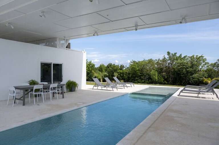 Pool deck and patio furnished for lounging and dining.