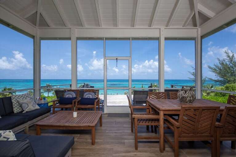 Our ocean-view screened porch, furnished for lounging or dining.