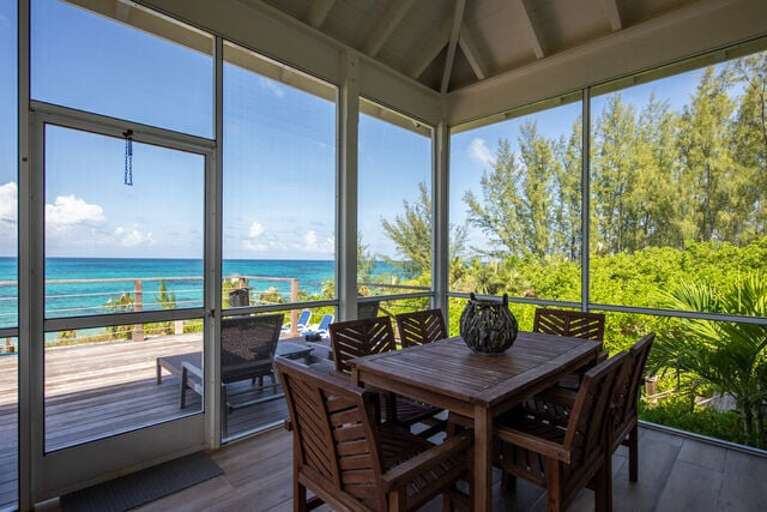 Our ocean-view screened porch, furnished for lounging or dining.