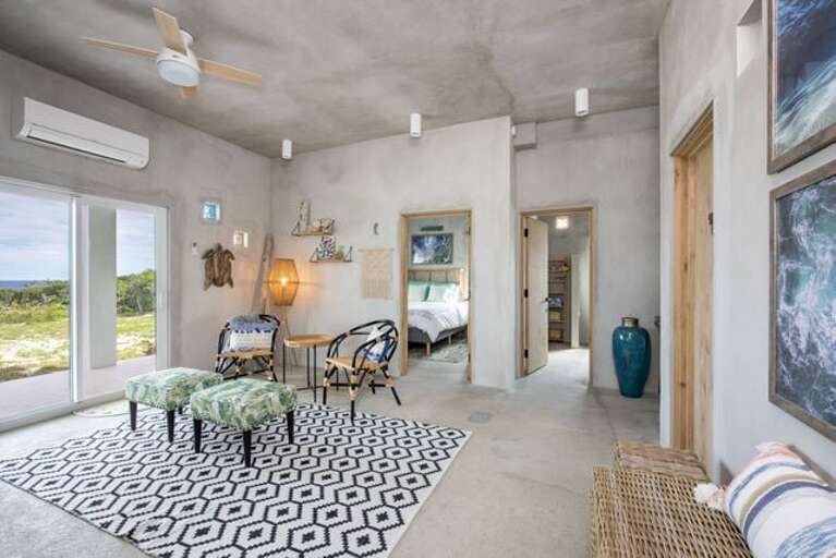 The first-floor family room has a 60" curved smart TV, sofa and chairs.