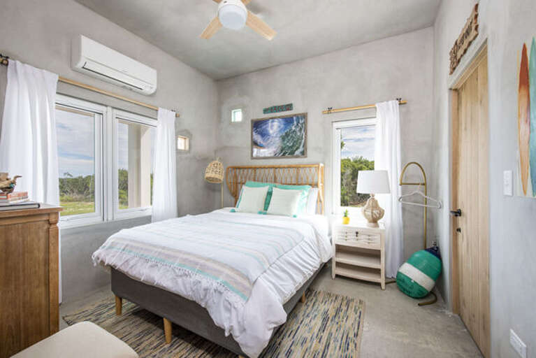 The Surf Shack suite has a queen bed, an ocean view, and an ensuite full bath with a turquoise theme and large walk-in shower.