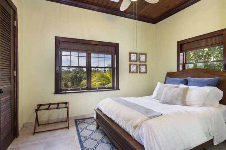 Guest bedroom with queen bed and garden view.
