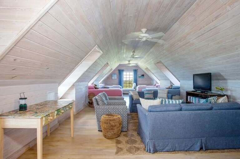 Finished attic with living area in foreground.  Perfect place for the kids!