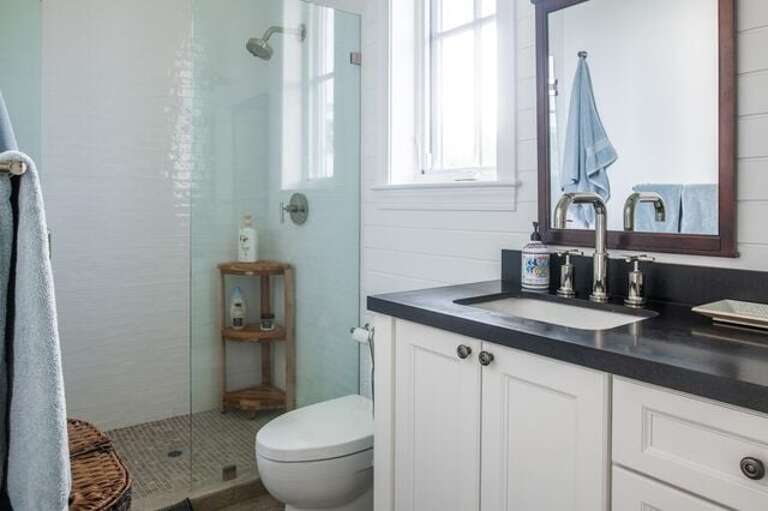 Bath with walk-in shower, and double sinks.