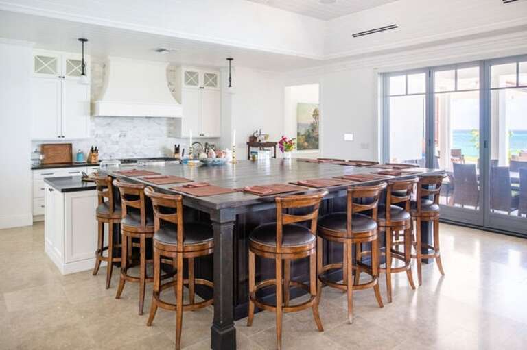 Kitchen island, seats 10 people comfortably with leather swivel back barstools.
