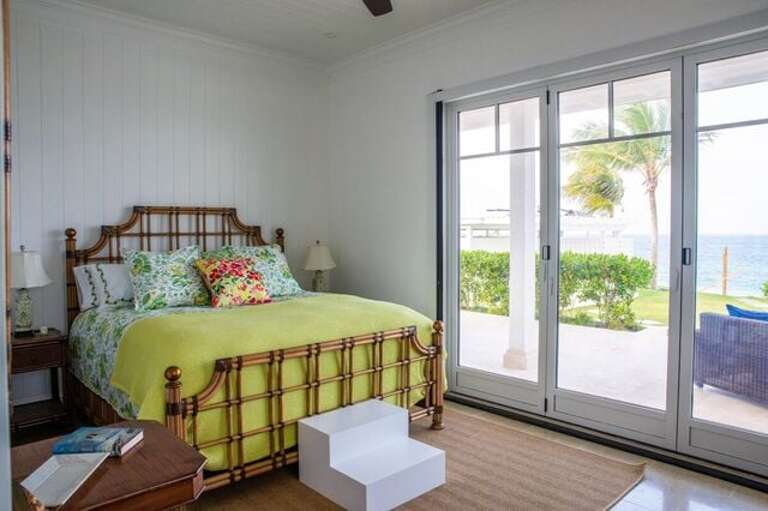 Orchid Room, main level.  King bed suite with full closet. Sliding door windows to outdoor patio with covered seated area and pool/beach access.
