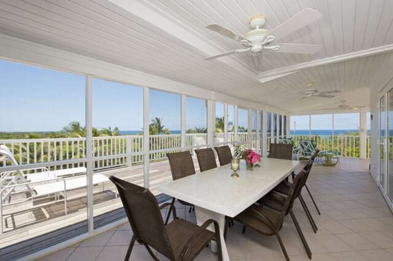 Dining area of our wrap-around screen porch with ocean views in both directions.