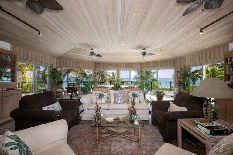 The magnificent high-ceilinged great room features sweeping 180-degree views of the ocean.