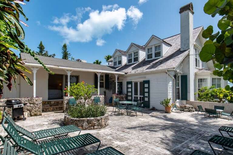 The terrace includes an outdoor eating area, lounge chairs, and an outdoor shower.