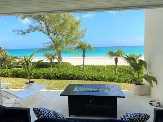 The ocean-view patio is furnished with lounge chairs and a propane fire pit.