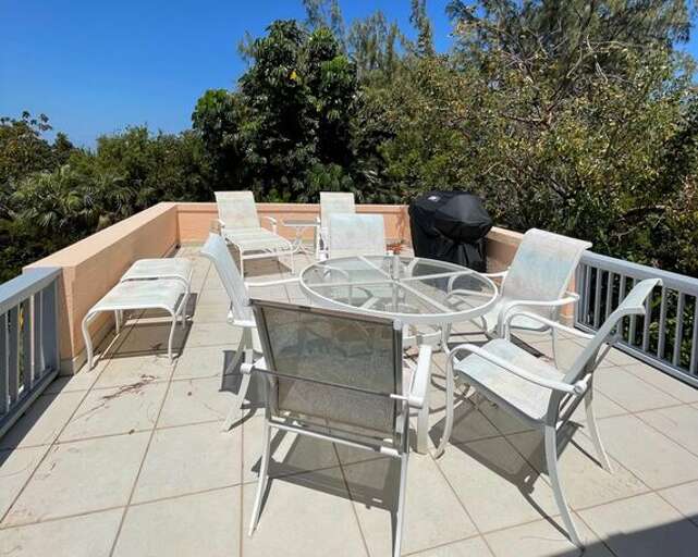 Patio with panoramic water views of both the ocean and the sound. It is furnished for both lounging and dining, and is equipped with a gas grill.