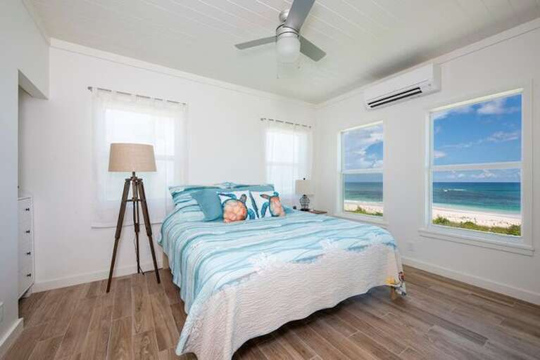 The master bedroom has a king bed, an ocean view, and an en-suite bath.