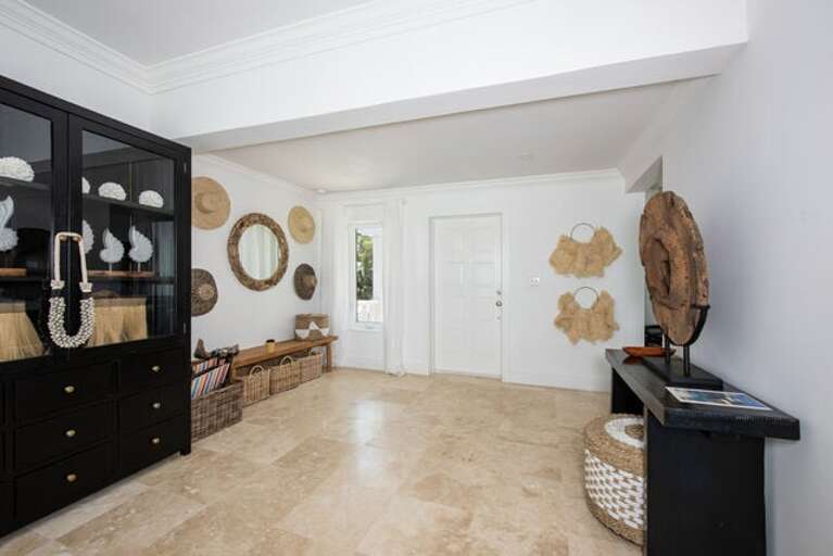 The entrance welcomes you with a touch of Indonesian-inspired furniture, perfectly complemented by sweeping views of Savannah Sound.