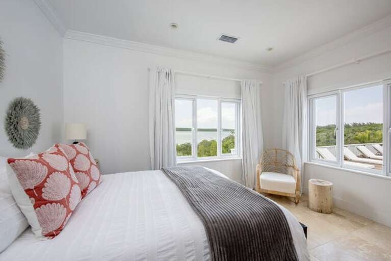 Second guest bedroom offers a cozy queen-sized bed, an elegant armoire, and a bathroom with a refreshing shower.