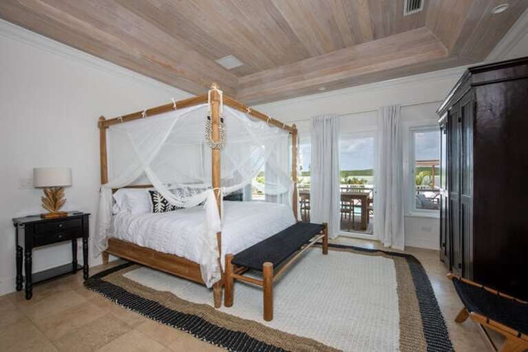 Master Suite adorned with an indulgent king-sized bed draped in white linens.