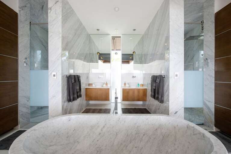 Bathrooms feature giant tubs carved from solid Carera marble.