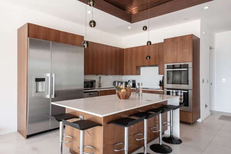 The open kitchen features top of the line Miele appliances including a 36''refrigerator, Master Chef double oven, and glass cooktop with retractable hood.