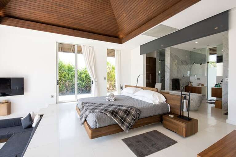 South side master bedroom suite with 20-foot vaulted ceiling. Each suite has a wall of glass with a sweeping view of the ocean. Amenities include 55-inch 4k 3D TV.