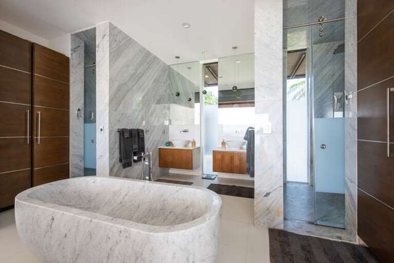 The ultra-luxury bathrooms feature Caesar stone and Carrara White slab walls and floors, top-of-the-line Hansgrohe Axor fixtures, and stand-alone tubs carved of solid Carrara marble.