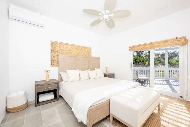 Bedroom Three with king bed, garden view, and sliding door to the patio.