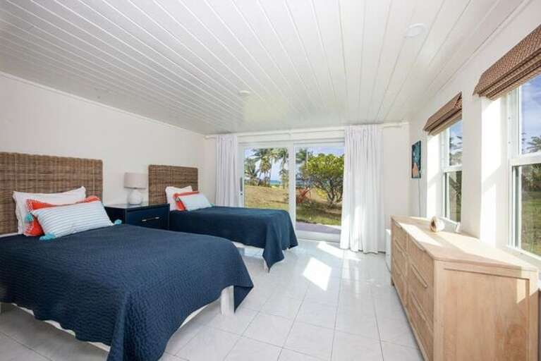 Bedroom with two twin beds, beautiful en-suite bathroom featuring walk-in showers.