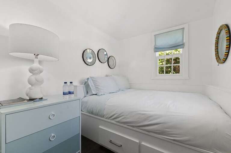 One of two Pool House bedrooms, each with a full bed and a shared bath.