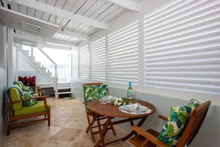 Lillian's has a private patio with a coral stone floor, furnished for lounging and dining