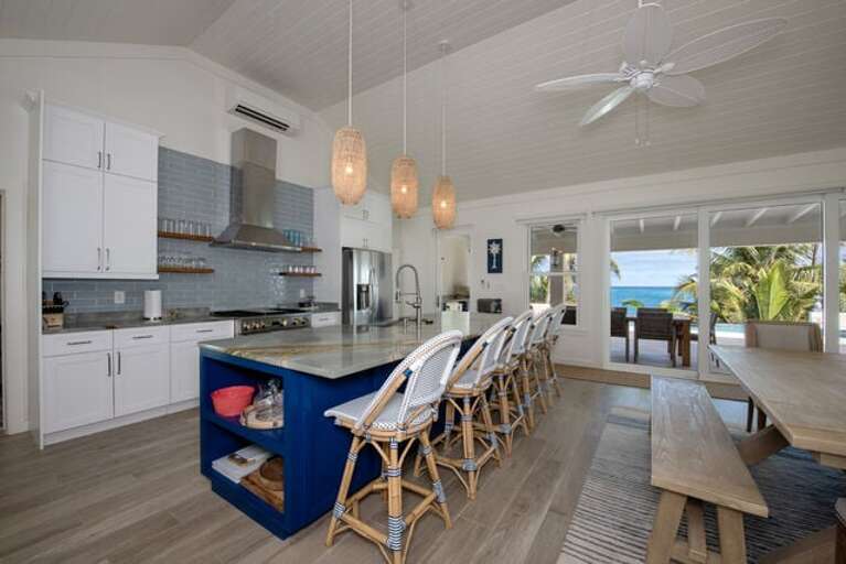 Fully equipped ocean-view kitchen with stainless steel appliances and island with seating.