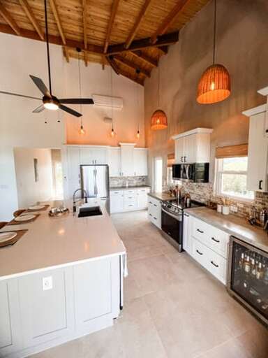 Our luxurious fully equipped kitchen featuring stainless steel appliances, quartz island, and a wine