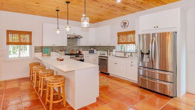 The luxurious island kitchen is fully equipped and finished in quartz and stainless steel.