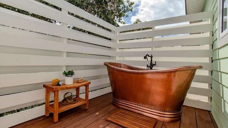 The master bath steps out onto a private enclosed deck with a spectacular copper soaking tub.