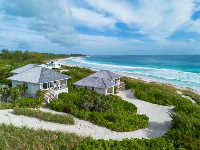 Perfectly located on three private acres with 200 feet of powdery pink sand beach.