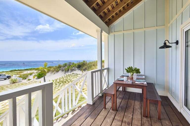 Covered porch with ocean view dining table.