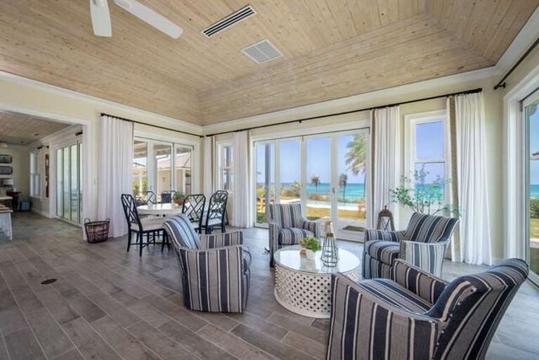 Great room with an ocean view!  Dining table at left can seat up to 10.  One of two sitting areas at right.