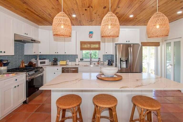 The fully equipped island kitchen with additional bar seating.