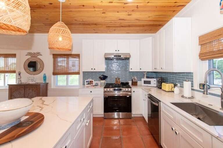 The fully equipped island kitchen features a gas range and is luxuriously finished in quartz and stainless steel.