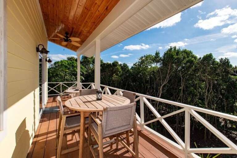 Poinciana House is nestled in a grove of trees and elevated to create a delightful treehouse ambience.