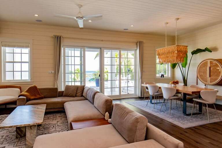SeaDuced grand room has expansive sliding glass doors which lead to a covered patio and directly onto the pool deck.