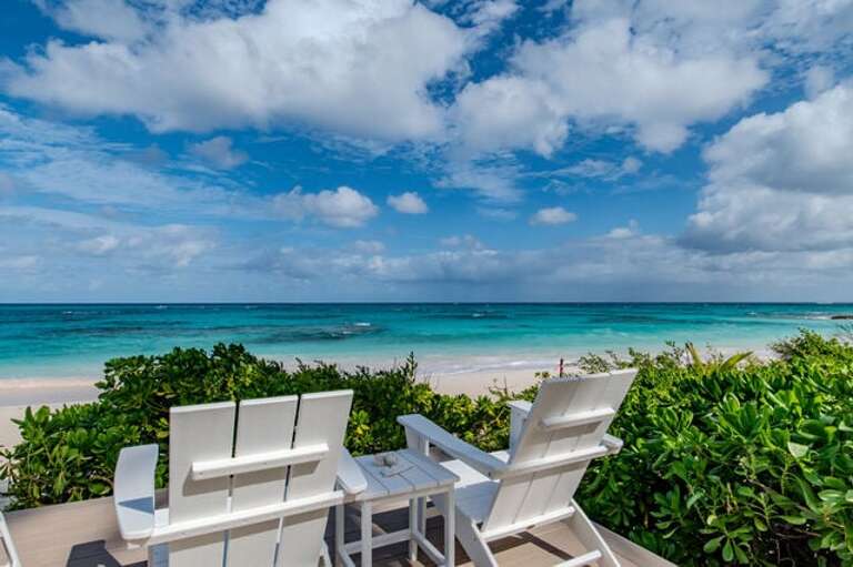 View the pink sands of the beach and blue/green hues of the ocean water.