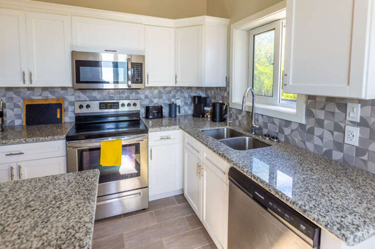 Fully quipped Kitchen with stainless steel appliances and quartz countertops.