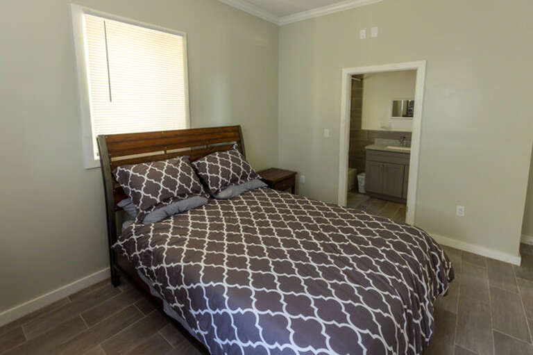 The large master bedroom has a queen bed, large closet and an en-suite bathroom with bathtub and shower.
