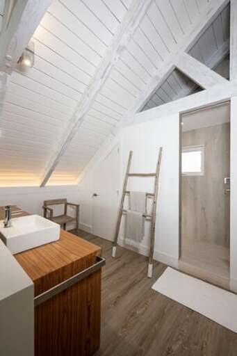 The en-suite bath features double sinks open to the ocean view, a private water closet, and a walk-in shower