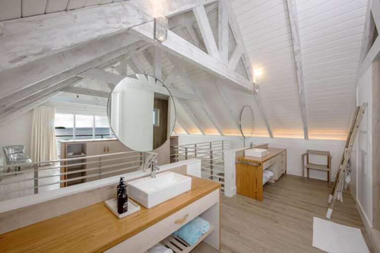 The Cottage's en-suite bath features double sinks open to the ocean view, a private water closet, and a walk-in shower.