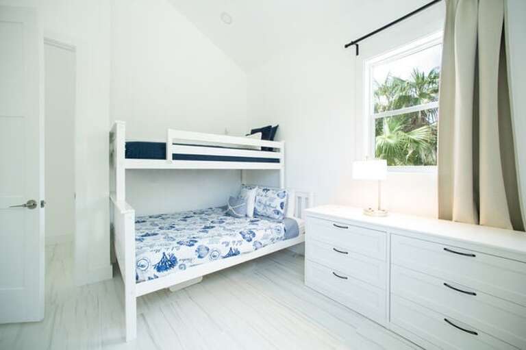 The guest bedroom is furnished with a twin XL-over-queen bunk bed and is right next to the second full bath.