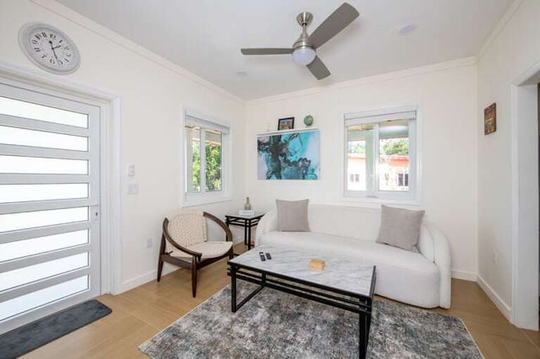 The living room is equipped with a wall-mounted flat screen smart TV and a sofa and chair.