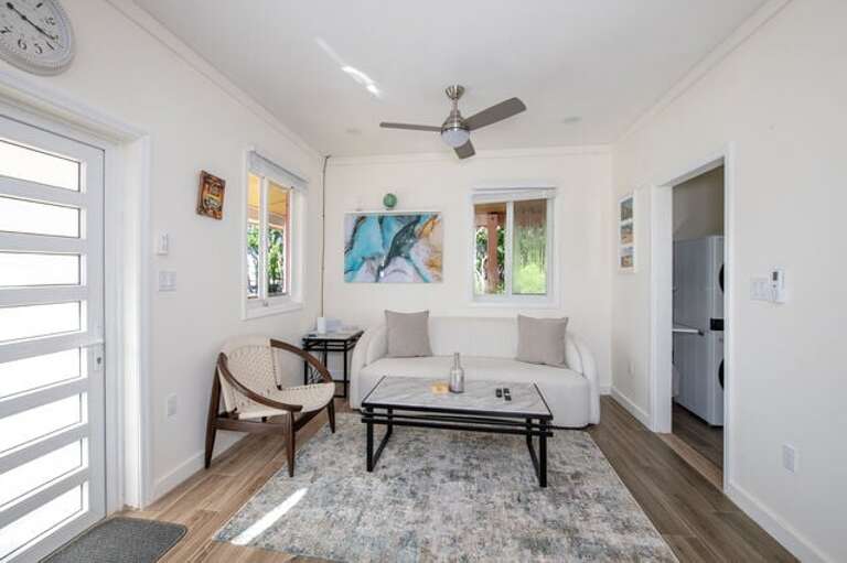 The living room is equipped with a wall-mounted flat screen smart TV and a sofa and chair.