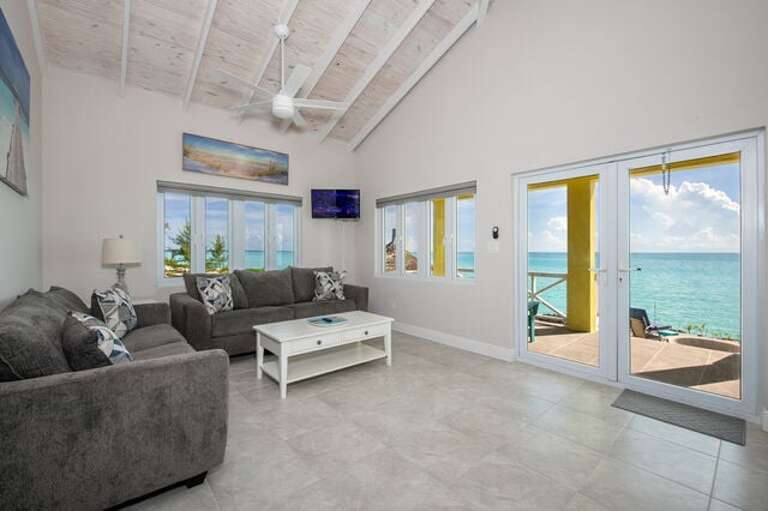 The Guest Cottage living area looks at the sea through a wall of large windows and glass doors.