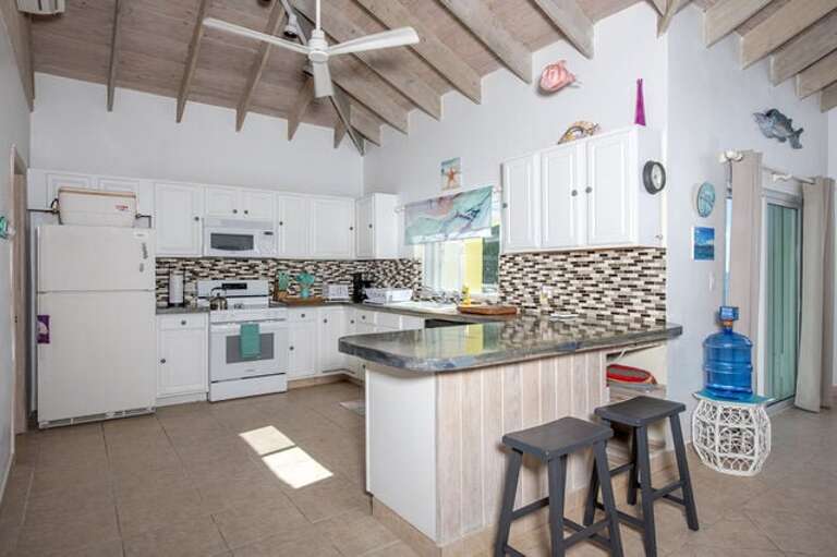 Modern fully equipped kitchen with ocean views and a peninsula with extra seating.