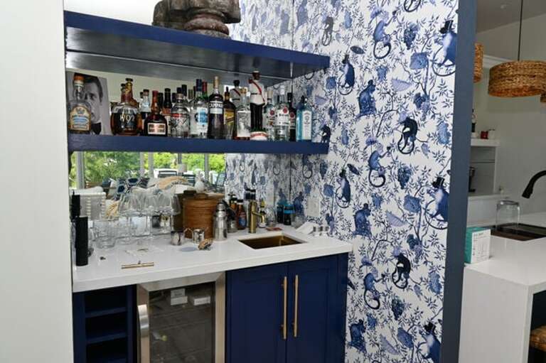 “Drunk Monkey” wet bar with a quartz counter, brass sink, wine fridge, and a proper martini setup.
